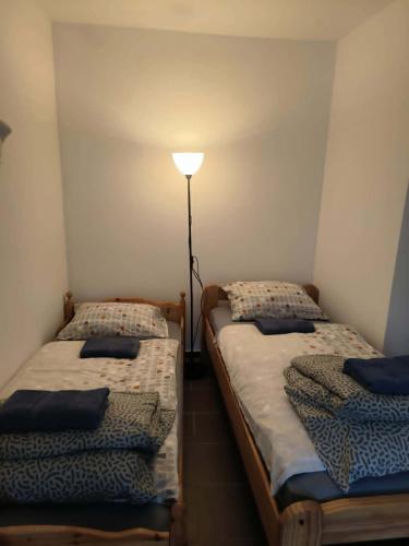 two twin beds in a room with a lamp at Apartament przy weneckim mostku in Kowary