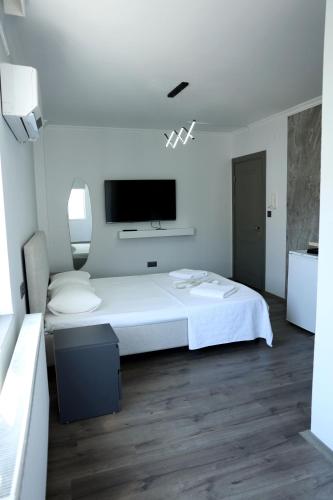 a bedroom with a white bed and a flat screen tv at Ceylan Apart Otel in Tekirdağ