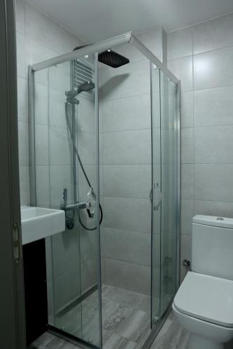 a bathroom with a glass shower and a toilet at Ceylan Apart Otel in Tekirdağ