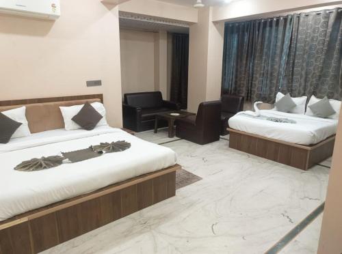 a hotel room with two beds and a chair at Hotel Pearl -Jaipur Pink City Centre in Jaipur