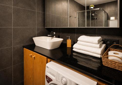 a bathroom with a sink and a washing machine at City Center apartment in Jelgava in Jelgava