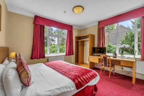 a bedroom with a bed and a desk with a computer at Seka Inn Hotel in Crowthorne