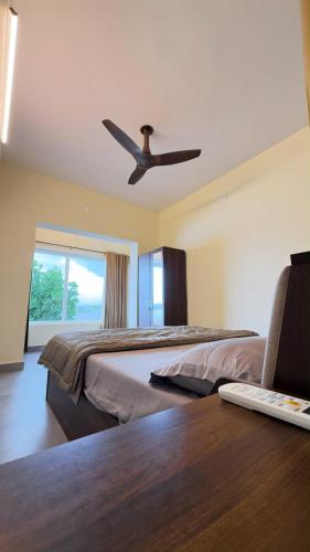 a bedroom with two beds and a ceiling fan at Kadapu stay in Udiyāvara