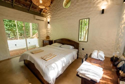 a bedroom with a large bed and a window at Clove Bentota in Walagedera