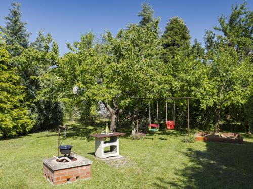 a park with a tree and a grill and a swing at Apartment Times by Interhome in Badacsonytördemic