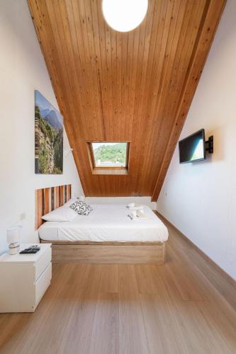 a bedroom with a bed and a wooden ceiling at Apto Aloha Panticosa | Piscina | WIFI | Vistas in Panticosa