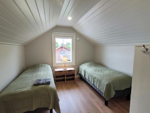 two beds in a small room with a window at Villa Catharina in Kristinestad