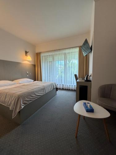 a hotel room with a bed and a table at Hotel a Restaurant Výpřež in Děčín