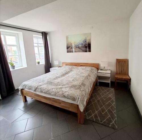 a bedroom with a large bed and two windows at Ferienwohnung Till in Mölln