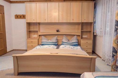 um quarto com uma cama e uma cabeceira em madeira em Ferienwohnung Aschenwald em Ramsau im Zillertal