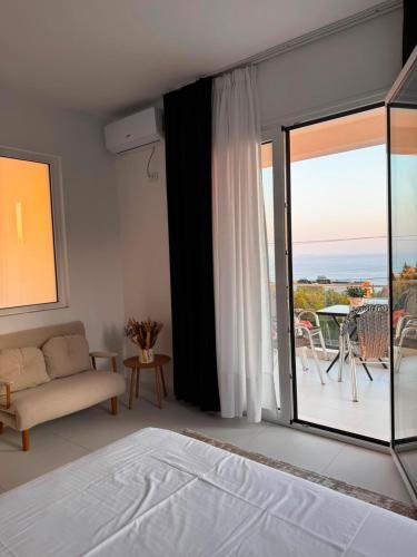 a bedroom with a bed and a view of a patio at Villa Thalassa Lal'Andrea in Dhërmi