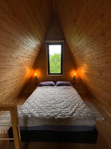 a bed in a wooden room with a window at Aba Ula in Martvili
