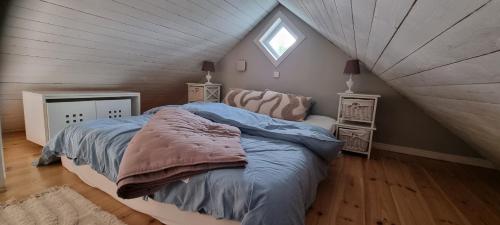 a bedroom with a bed in a attic at The Red Mini Cottage in Huddinge