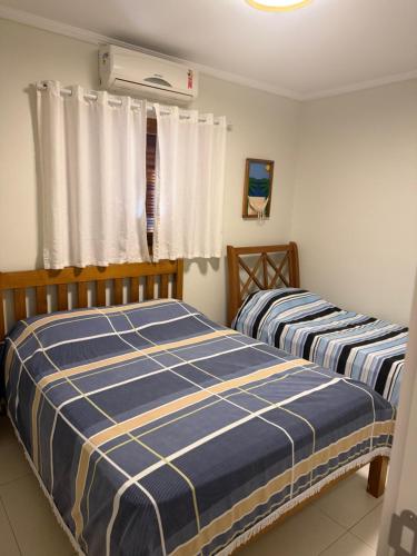 a bedroom with two beds and a window at casa 300 mts da praia in Juquei