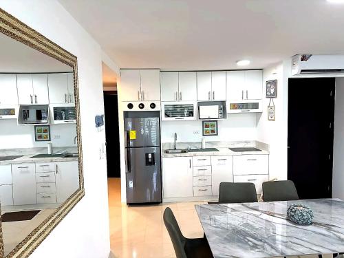 a kitchen with white cabinets and a table and a mirror at Punta Centinela - Townhouse 200 in Punta Blanca