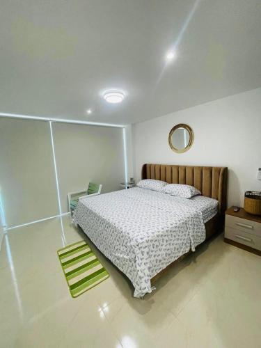 a bedroom with a bed and a mirror on the wall at Punta Centinela - Townhouse 200 in Punta Blanca