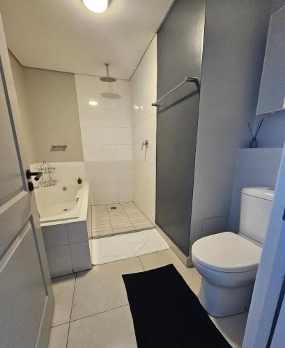 a bathroom with a toilet and a sink and a shower at R&R at Summerview Sonstraal Heights in Windsor Park