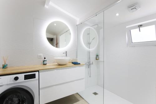 a bathroom with a sink and a washing machine at Villa Trafal - Proche plage in Saint-Michel-en-lʼHerm
