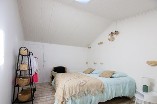 a bedroom with a bed in a white room at Villa Trafal - Proche plage in Saint-Michel-en-lʼHerm