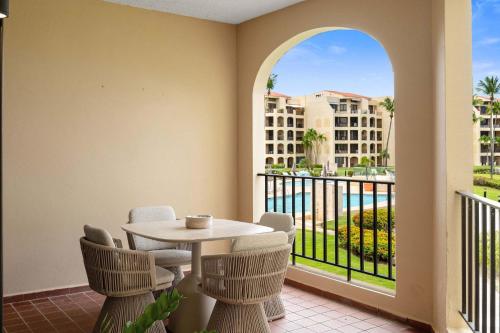 a balcony with a table and chairs and a view of a building at Boho 2BR Retreat - Ocean View Terrace & Pool in Buena Vista