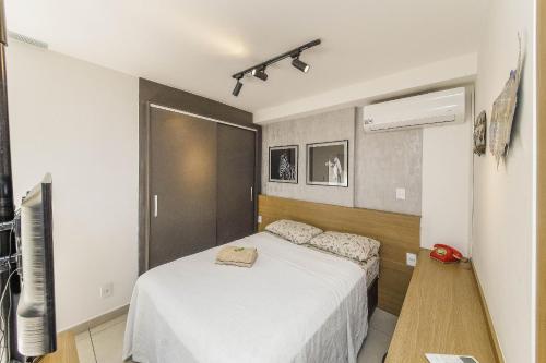 a bedroom with a white bed and a television at Studio Luxo Completo Independência 915- São Mateus in Juiz de Fora