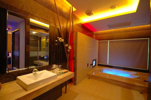 a bathroom with a sink and a bath tub at Norway Forest Villa Motel in Taipei