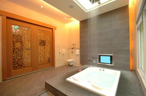 a bathroom with a tub and a toilet and a window at Norway Forest Villa Motel in Taipei