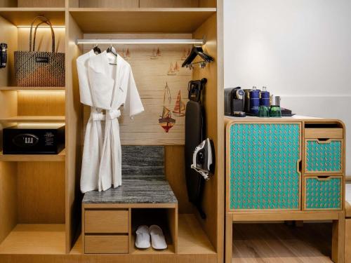 a closet with a white robe hanging on a wall at Grand Mercure Krabi Ao Nang in Ao Nang Beach