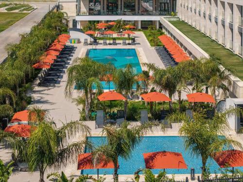 an aerial view of a resort pool with orange umbrellas at Mercure Antalya Belek in Belek
