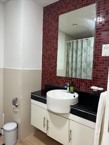 a bathroom with a white sink and a mirror at Cosy Studio - Desert Breeze in Ghantoot