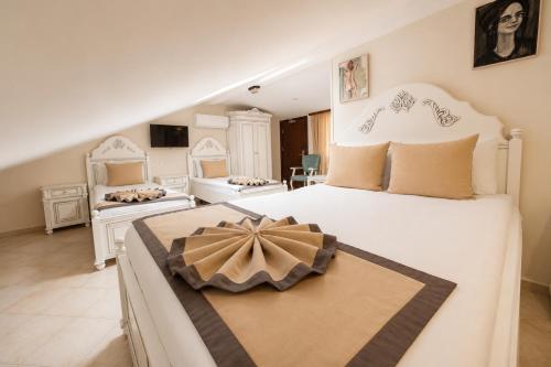 a bedroom with a large white bed with a bow on it at La Paloma Hotel in Antalya