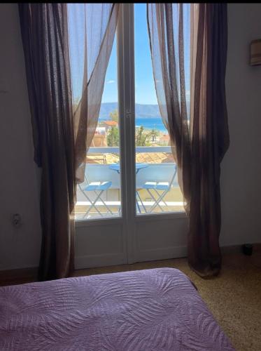 a bedroom with a window with a view of the ocean at Maison De La Mer in Isthmia
