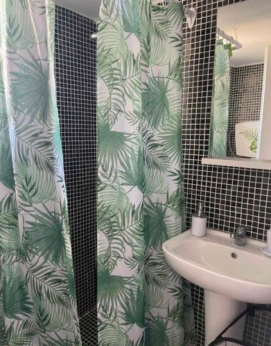 a bathroom with a shower curtain with a sink at Maison De La Mer in Isthmia
