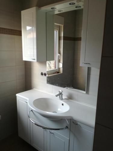 a bathroom with a white sink and a mirror at Bungalow Schwielochsee in Schwielochsee