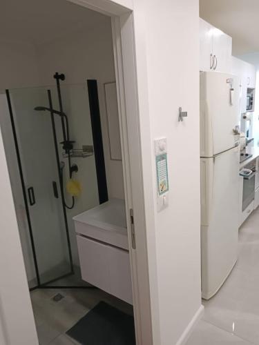 a kitchen with a refrigerator and a sink at Dizengoff 20 in Netanya