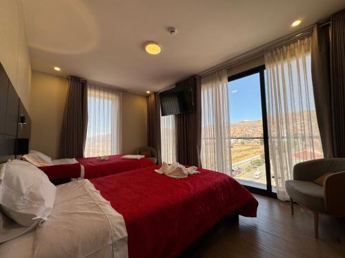 a hotel room with two beds and a large window at Hotel San Miguel Cusco in Cusco