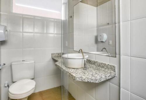 a white bathroom with a sink and a toilet at Pousada Duas Praias in Guarapari