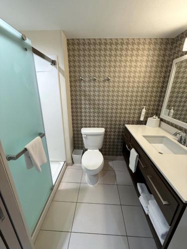 a bathroom with a toilet and a shower and a sink at Home2 Suites By Hilton Bloomington Normal in Normal