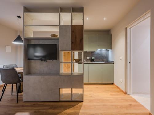 a kitchen with a tv and a table in a room at Apartment La Spada by Interhome in Ossana