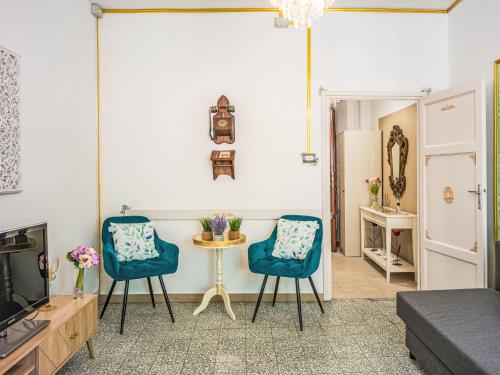 a living room with two blue chairs and a tv at Apartment Nido nel centro by Interhome in Camaiore
