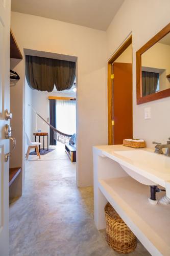 a bathroom with a sink and a mirror at Jaakbal Tulum in Tulum