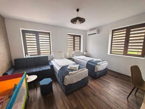 a living room with two beds and a couch at Къща за гости Старлес in Malko Tŭrnovo