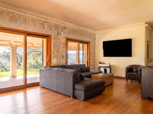a living room with a couch and a tv at Villa S'Olioni by Interhome in Loceri