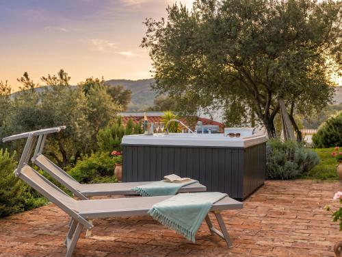 a chair and a hot tub in a garden at Villa S'Olioni by Interhome in Loceri