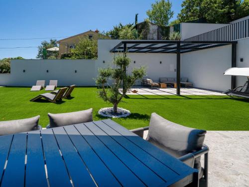 a blue table and chairs in a yard at Villa Black Imperium by Interhome in Mošćenička Draga