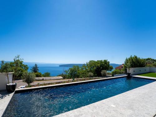 a swimming pool with a view of the water at Villa Black Imperium by Interhome in Mošćenička Draga