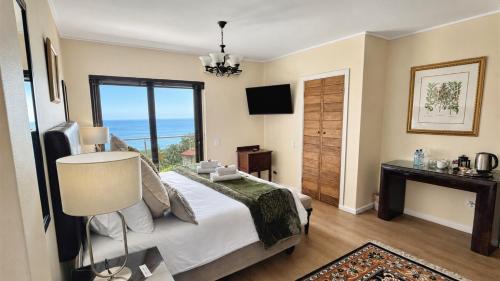 a bedroom with a bed and a view of the ocean at Aqua Terra Boutique Guesthouse - Simon's Town, Cape Town in Simonʼs Town