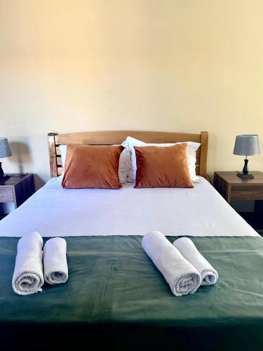 a bed with two pairs of towels on it at Cottage Shara - შარა in Ureki