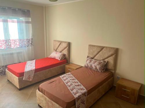 two beds in a small room with a window at Aparts 3 F3 BEJAIA VACANCE in Bejaïa