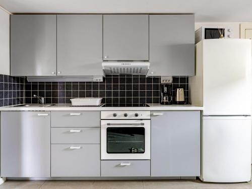 a kitchen with white cabinets and a white oven at Apartment Odal by Interhome in Halmstad